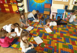 Zdjęcie przedstawia grupę dzieci wykonujących zadanie z programowania